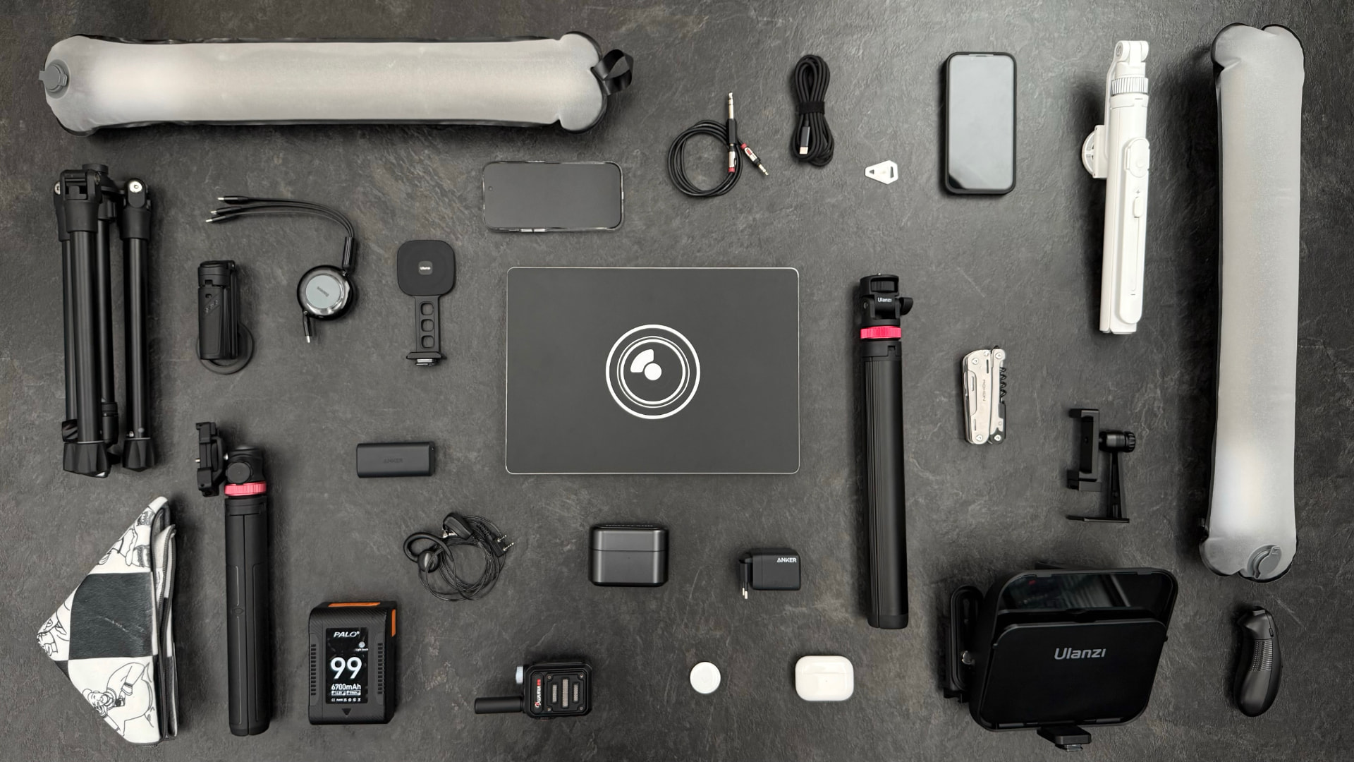 Flat lay de equipamentos de gravação para criadores de conteúdo organizados sobre superfície escura